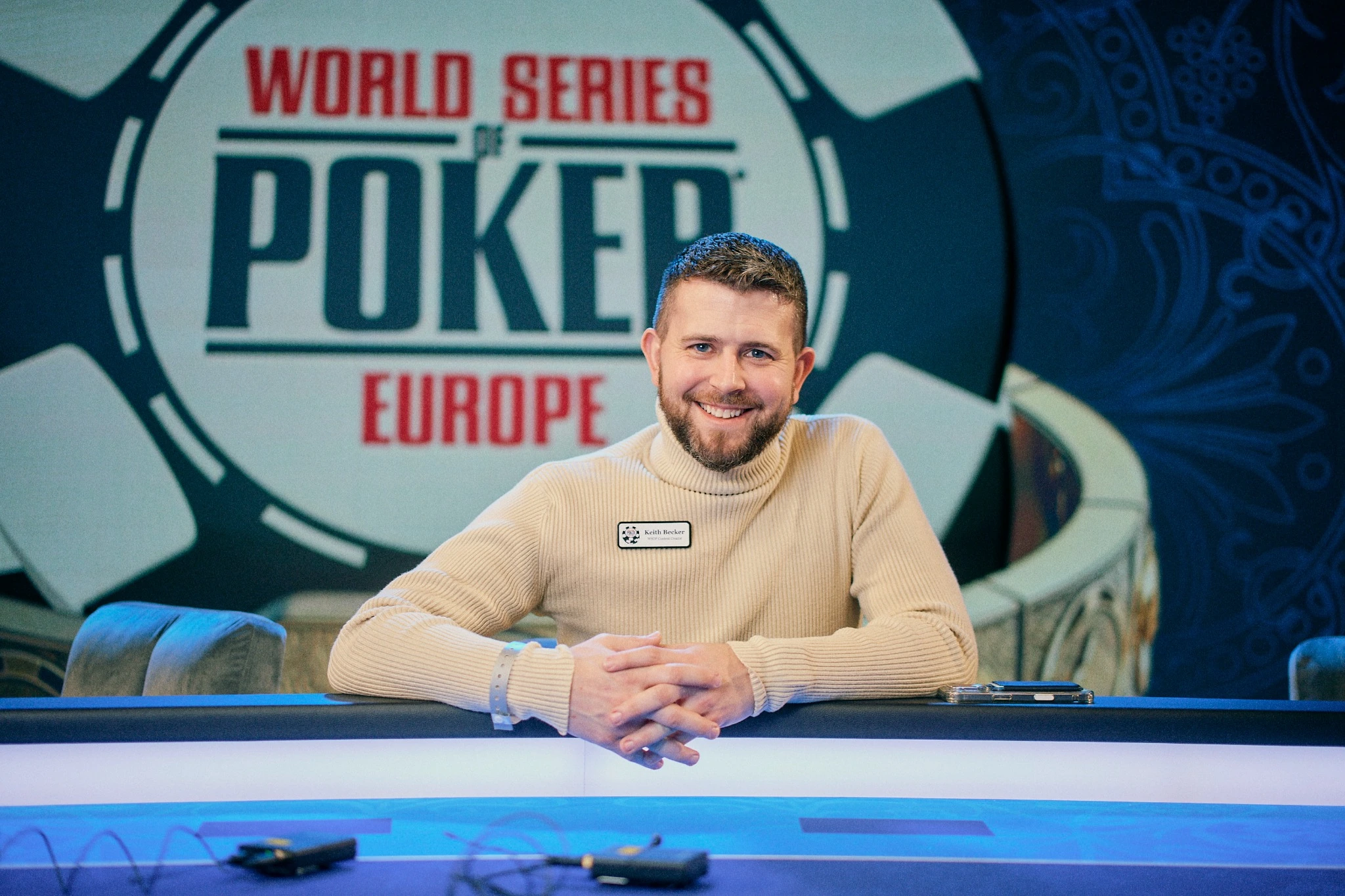 Keith Becker working digital media at a WSOP event, seated at the feature table